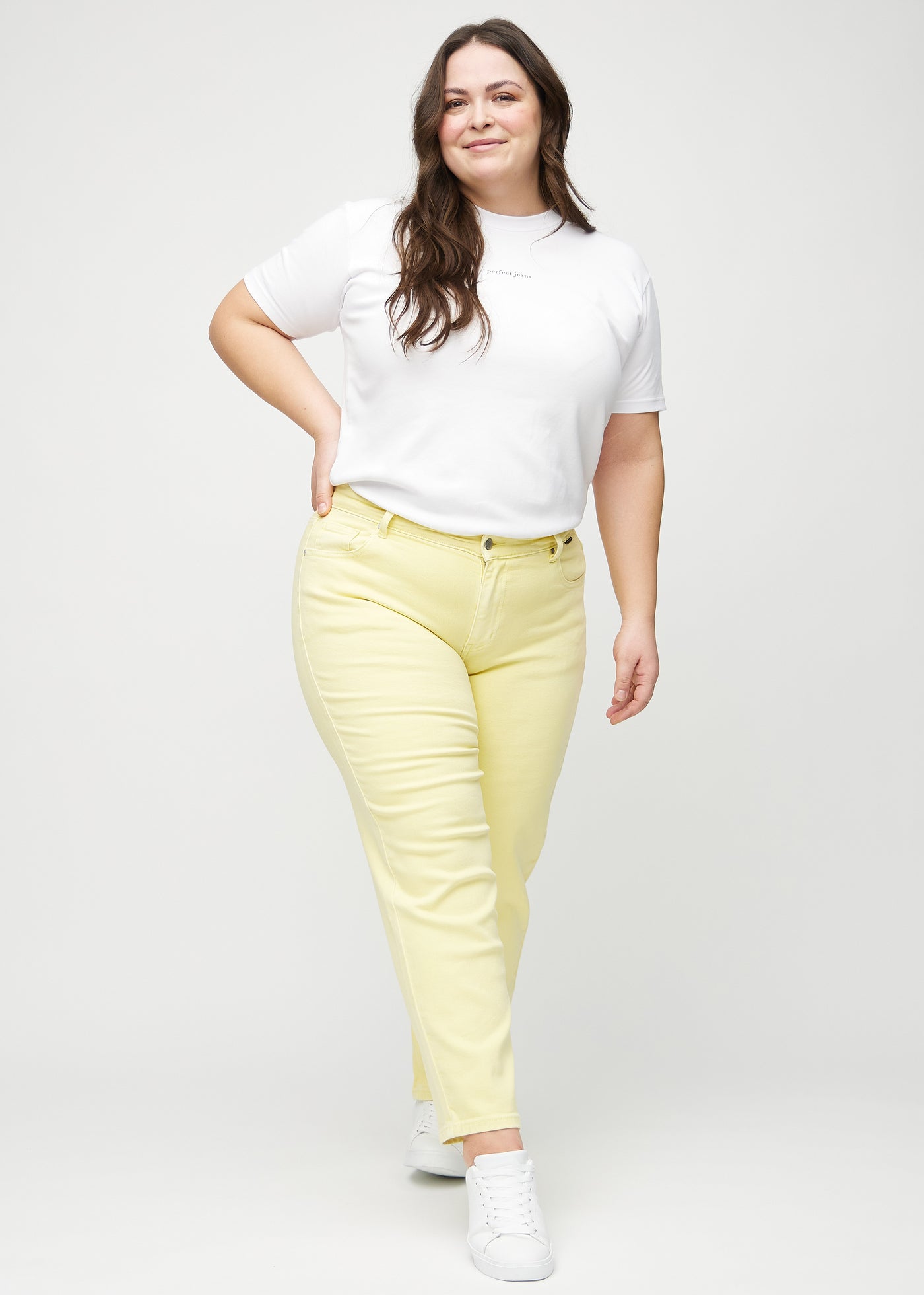 Fuldt billede af en plus-size model i lysegule regular jeans.