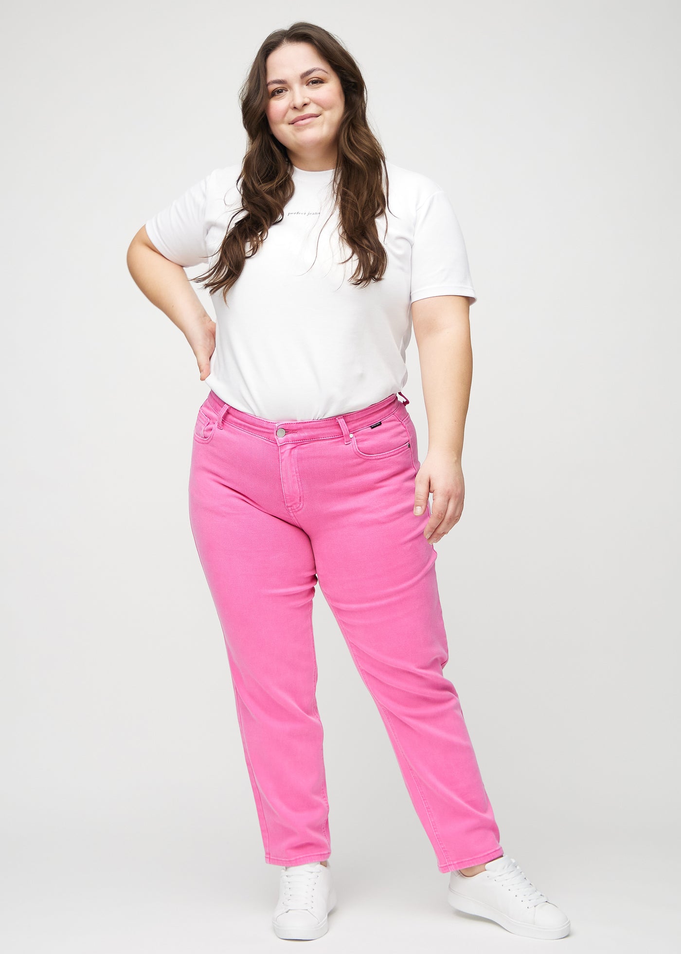 Fuldt billede af en plus-size model i lyserøde regular jeans.