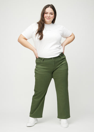 Fuldt billede af en plus-size model i mørkegrønne loose jeans.