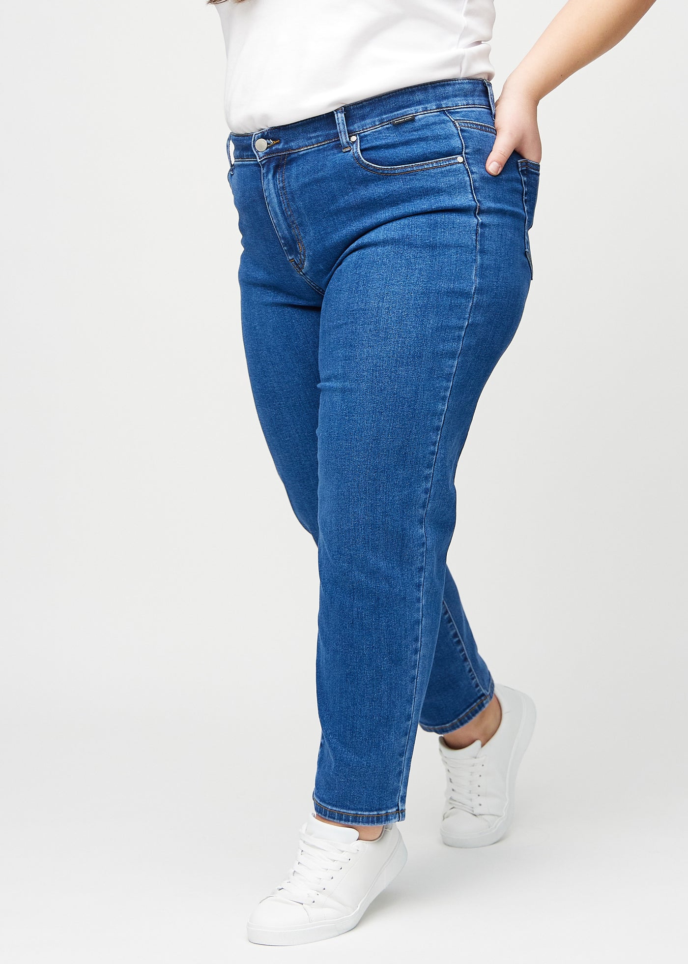 Mørk denim slim ultra high rise jeans set fra siden på en plus-size model.