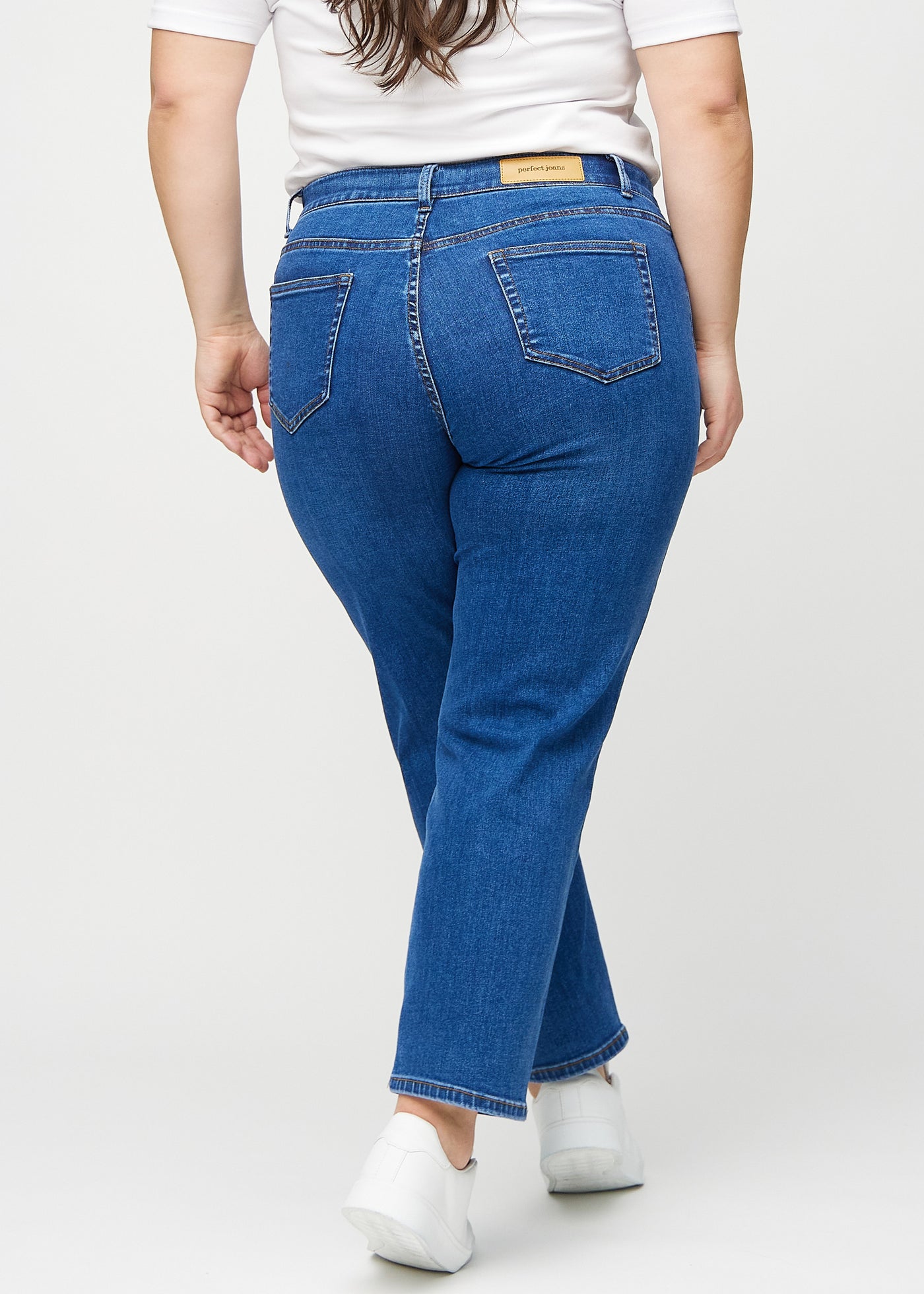 Mørk denim slim ultra high rise jeans set bagfra på en plus-size model, så man kan se hele produktet.